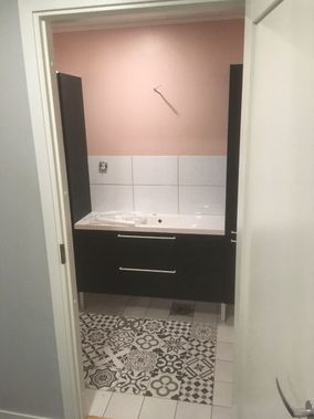 Vaaleanpunaista, valkoista ja mustaa yhdistelevä WC-tila