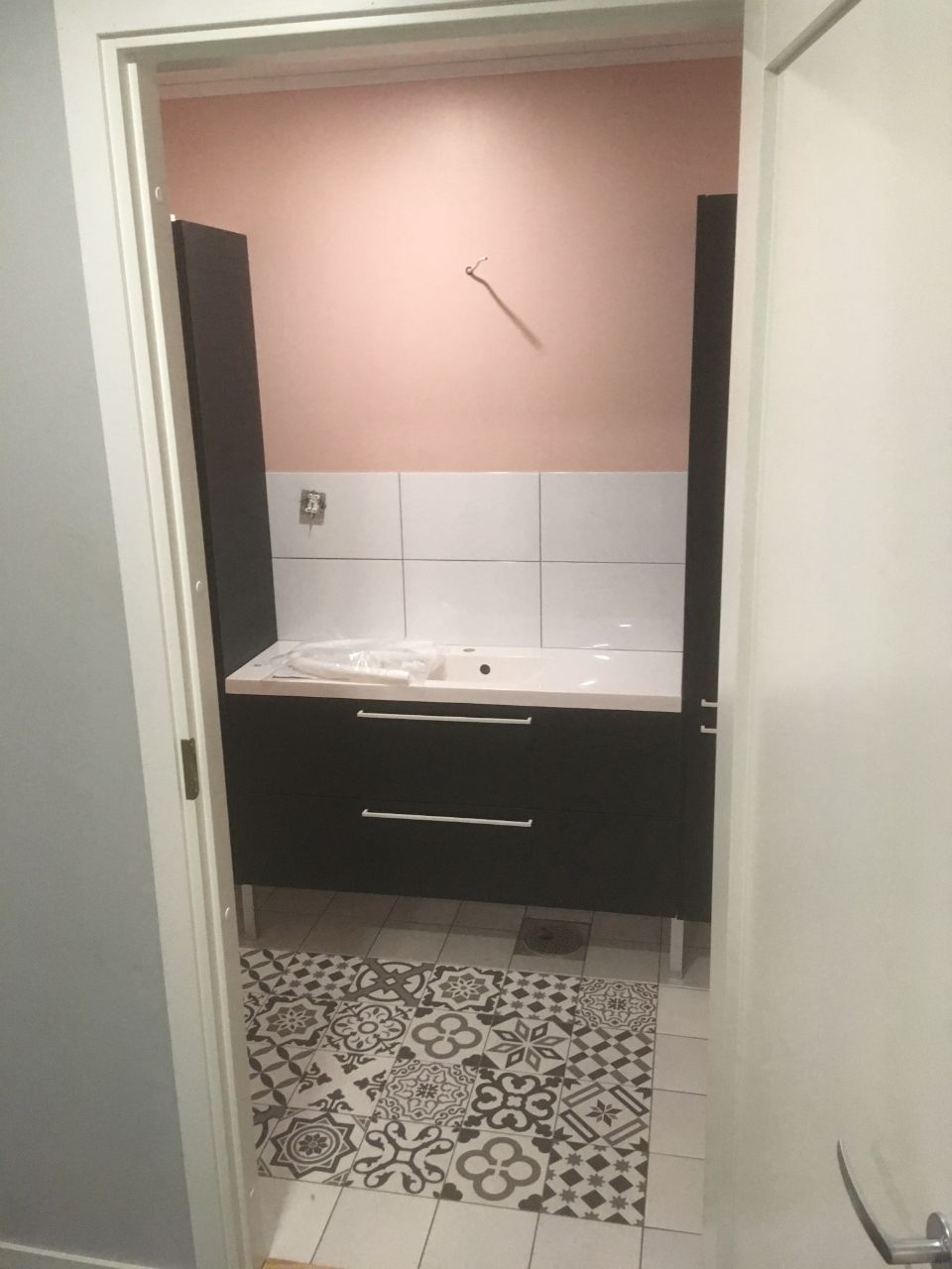Vaaleanpunaista, valkoista ja mustaa yhdistelevä WC-tila